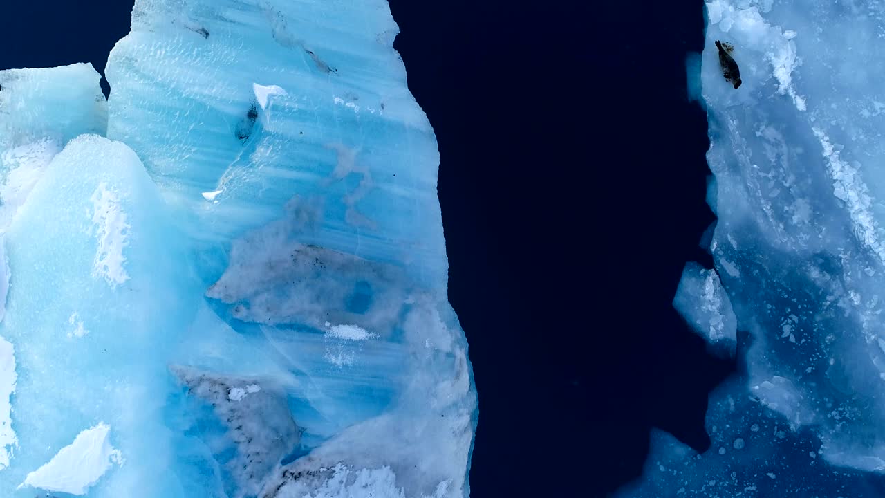 아이슬란드의 하 빙산 위에서 바다를 바라보는 공중 풍경 - 해가 지는 배경에는 빙하가 있습니다.