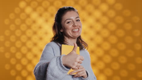 mujer feliz delirando sobre libro increíble, mostrando pulgares hacia arriba, fondo de estudio
