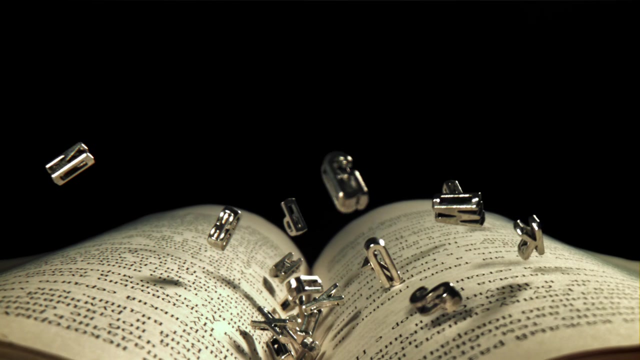 Lettere Metalliche che Cadono sulle Pagine di un Libro Aperto.