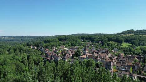 ascending aerial reveal shot over trees carennac village in dordogne valley france