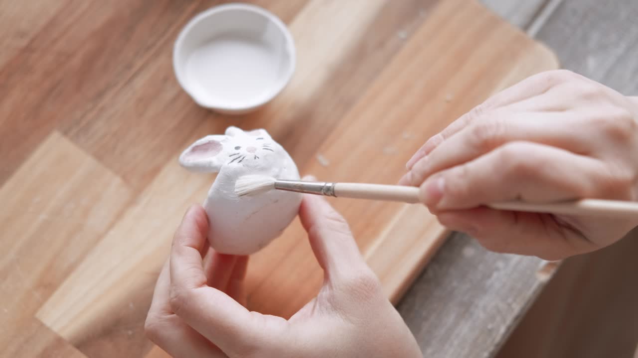 feliz pascua, artesanía mujer pintura conejo de pascua hecho de porcelana fría soporte para huevos de pascua, taller creativo, pasatiempo y preparación para las vacaciones de pascua
