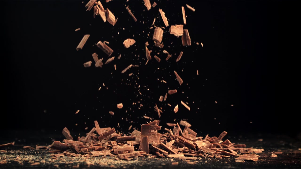 Slow Motion of Chocolate Shavings Falling on a Dark Background