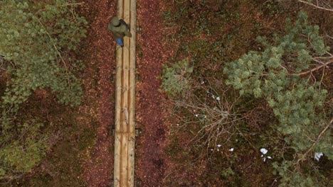 Young-man-enjoy-nature-on-hiking-trail-in-forest,-aerial-top-down-view