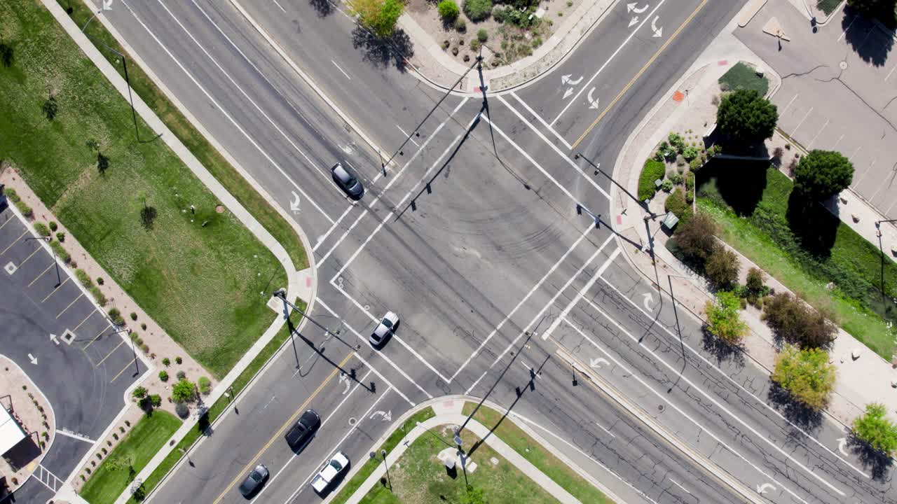 Aerial top-down circling and rising above crossroad with car traffic