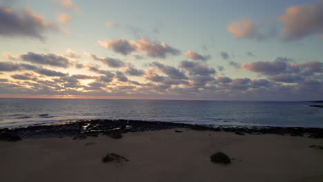 Luftaufnahme-Der-Meeresküste-Bei-Sonnenaufgang-Mit-Wolken-Im-Rücken