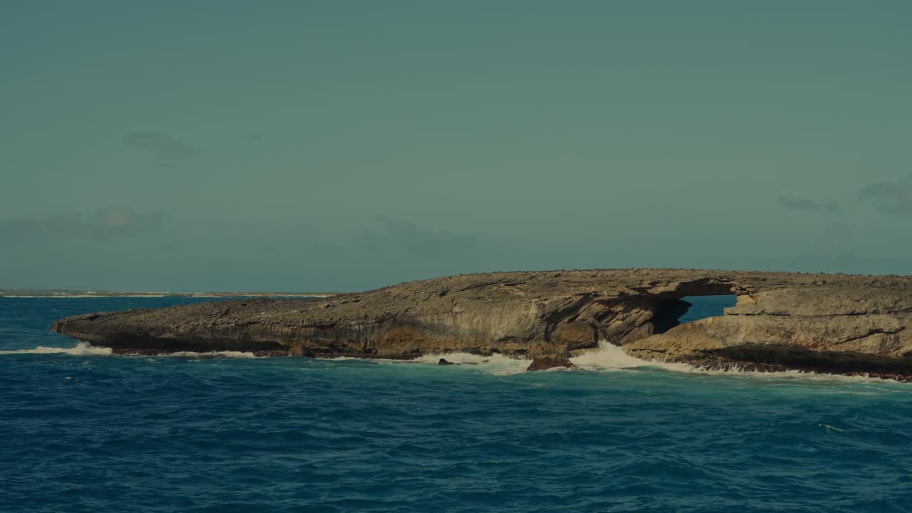 las ondas del océano azul profundo del pacífico chocan contra esta península rocosa con un puente de piedra natural en east point honolulu hawai