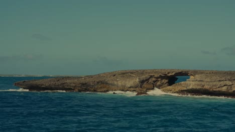 deep blue ocean waves from the pacific crash against this rocky peninsula with a natural stone bridge in east point honolulu hawaii