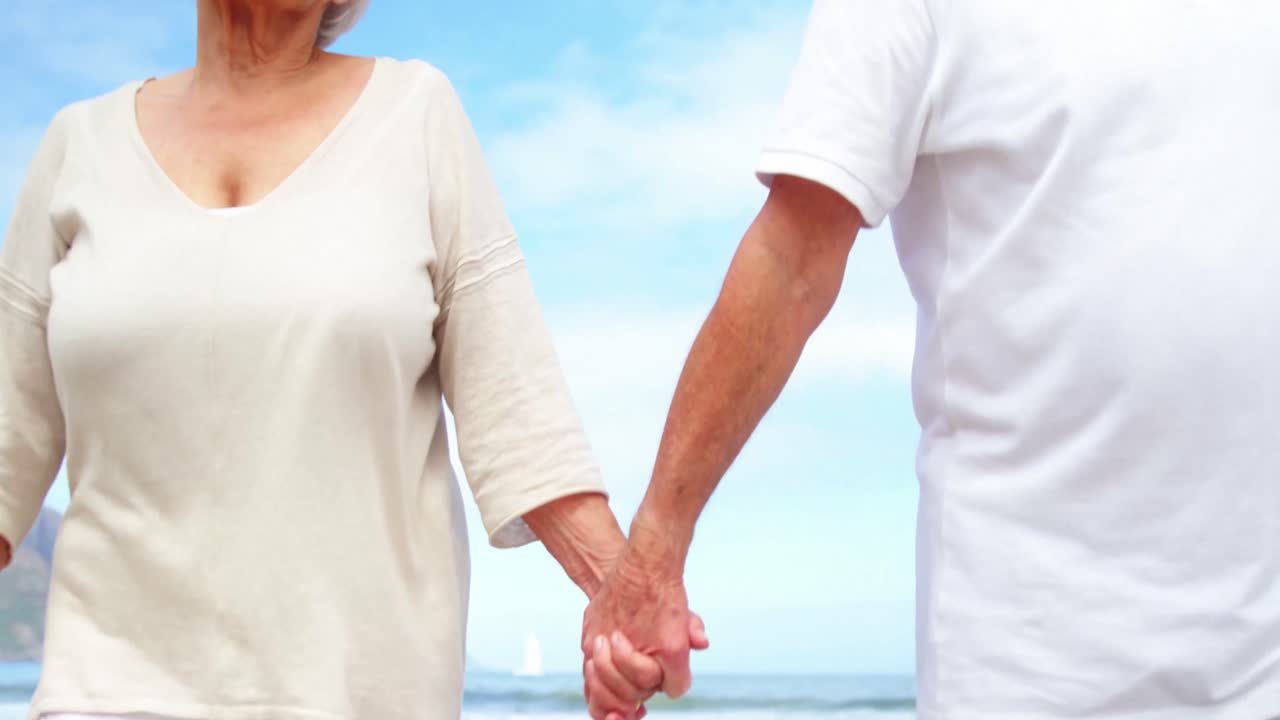 해변에서 걸어다니는 행복한 수험생 커플