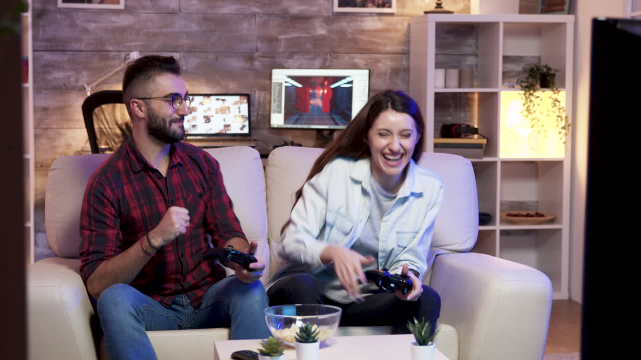 부부가 소파에서 비디오 게임을 하고 있다
