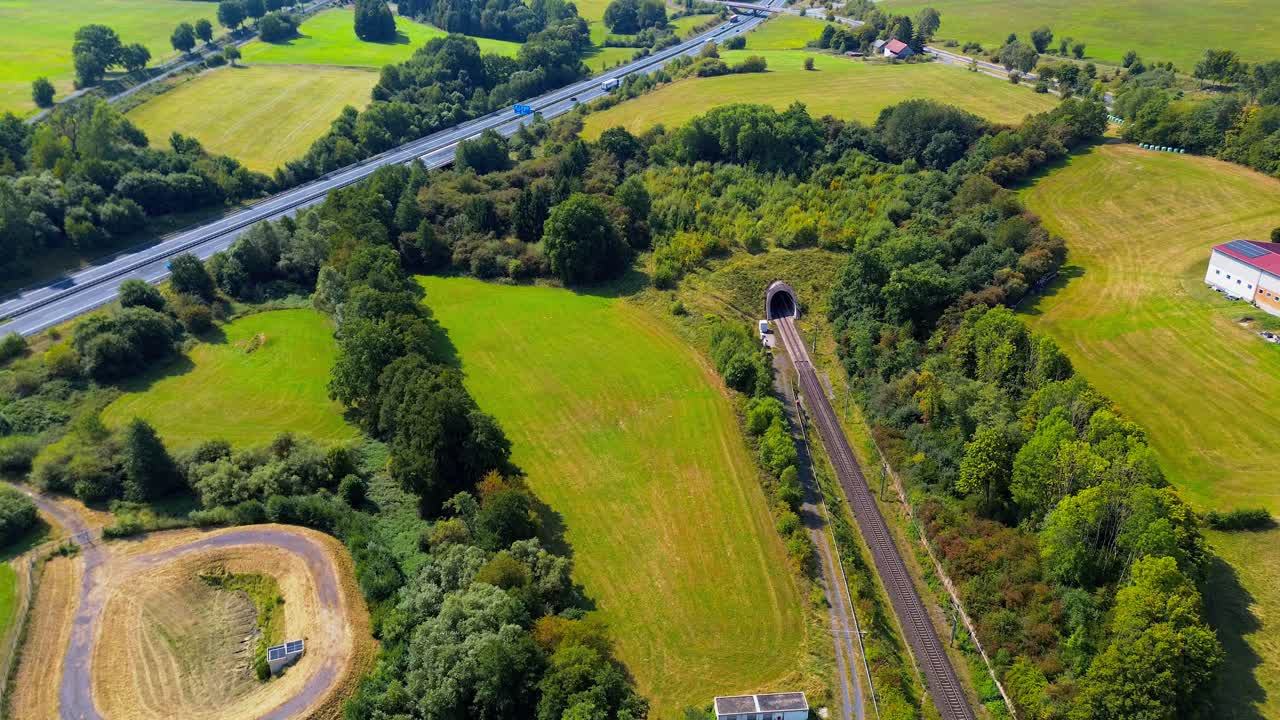 Aerial Drone View of Railway Tunnel Entrance in Green Countryside Landscape Near Highway