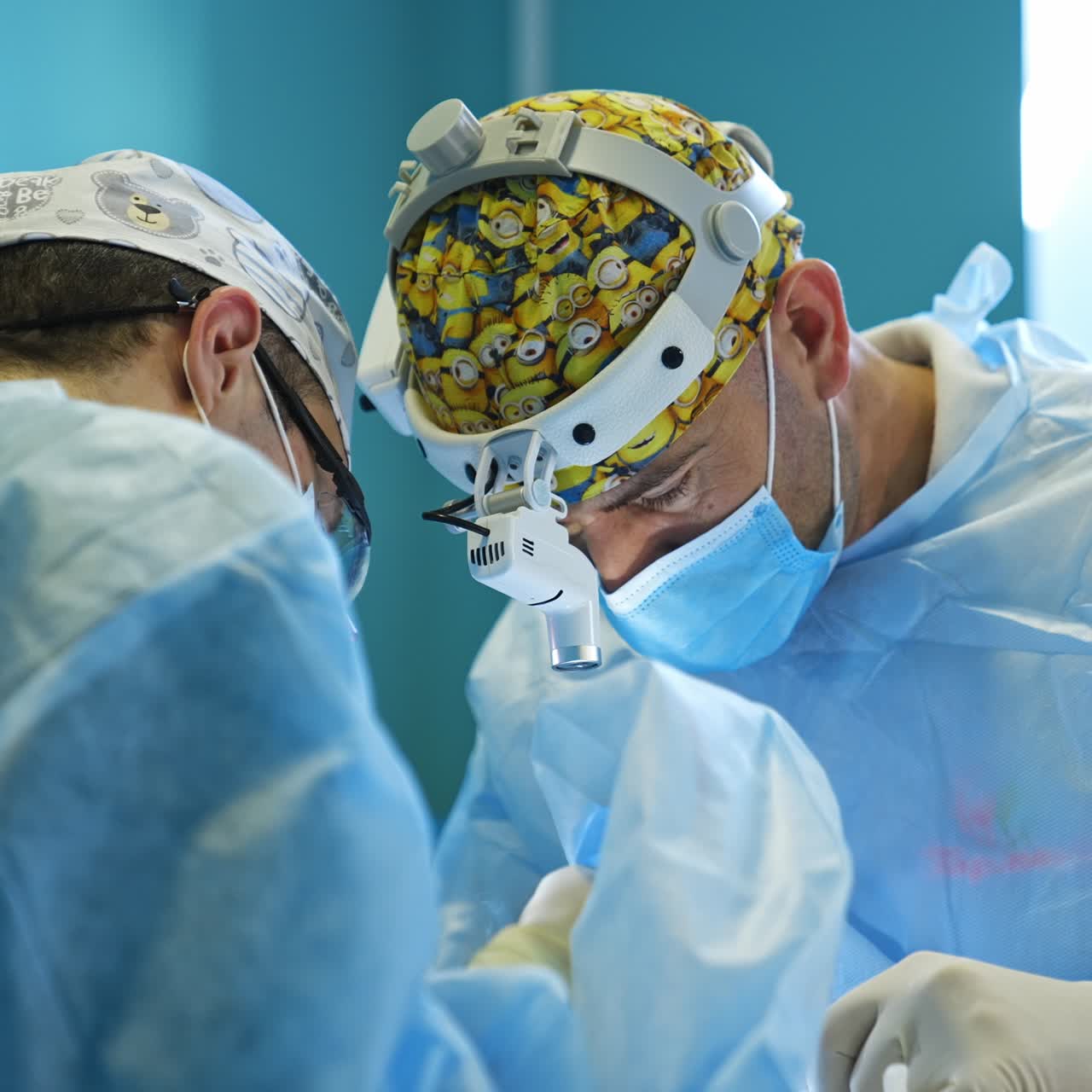 Doctors wearing the device flashlights on heads bent over the patient operating him. Electric tools are applied by surgeons