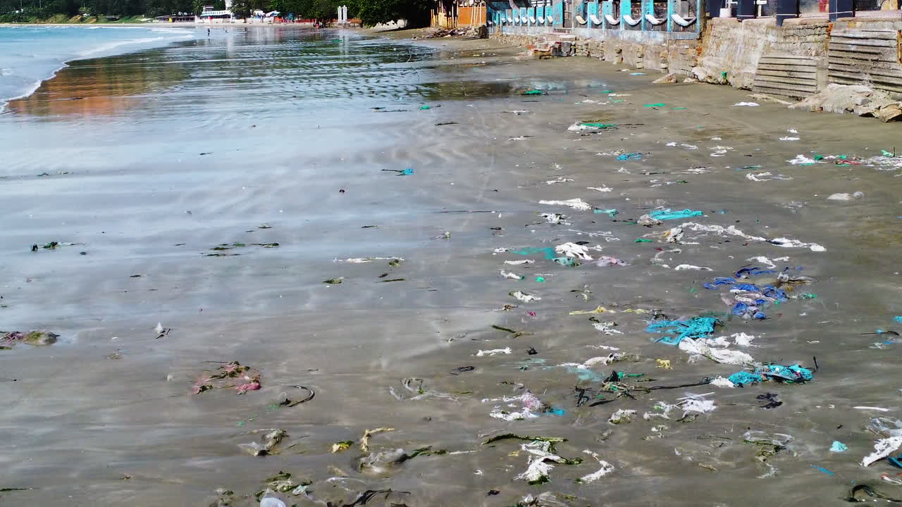 vuelo aéreo sobre una playa muy contaminada llena de basura plástica sucia
