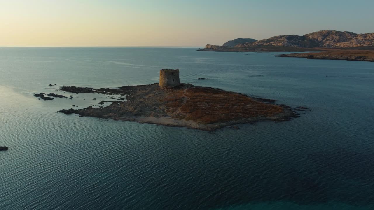 İtalya'daki güzel turistik tatil adası Sardinya'da, gün batımında berrak mavi turkuaz suya ve bir deniz feneri gözetleme kulesine sahip La Pelosa doğal kum plajı ve kumlu koy.