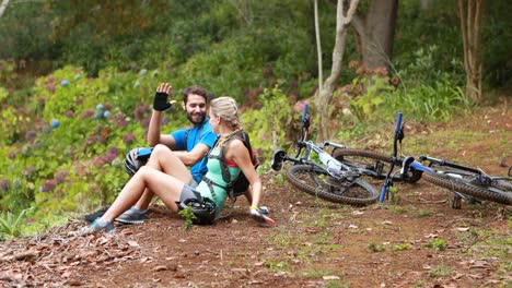 couple interacting while relaxing in forest