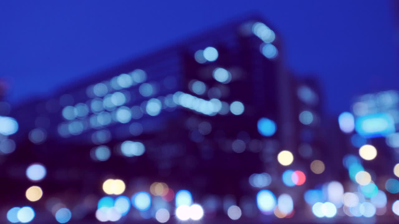 4k tono fresco vídeo desenfocado de vista nocturna urbana con transporte y transeúntes