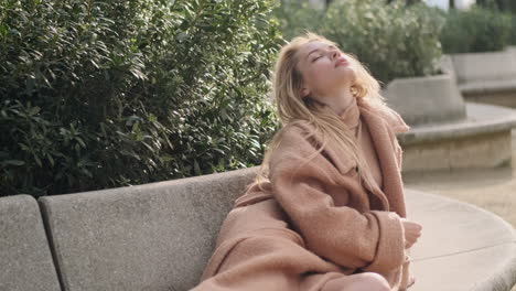 Young-woman-posing-on-bench-in-the-park.