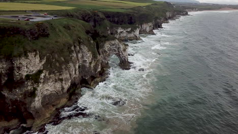 Cinematic-aerial-view-of-coastline-near-Dunluce-Castle