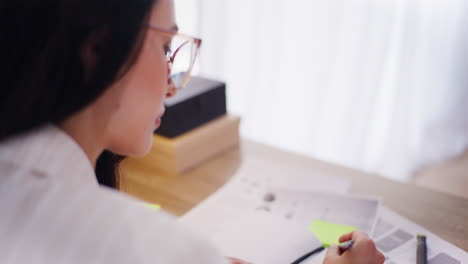 オフィスで働いている間にノートに書いている女性