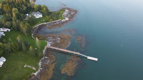 houses, docks, and water along coast in penobscot bay, maine | aerial view panning up | summer 2021