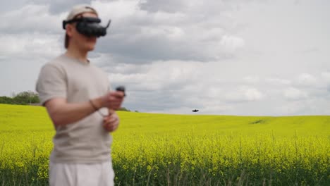 FPV-pilot-fly-drone-above-blooming-rapeseed-field,-dark-storm-cloud-behind