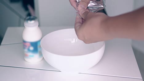 el hombre prepara el desayuno y vierte cereales de miel en el cuenco