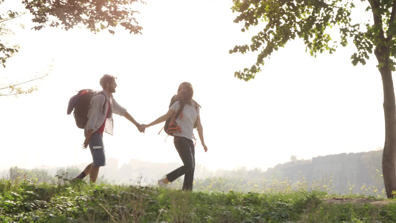 손을 잡고 는 젊은 부부, 배 여행자, 관광객들이 로마 수로 앞 언덕에 도착합니다. 파르코 데글리 아키도티 공원, 로마의 폐허, 로맨틱한 안개, 기타와 잠자리 봉투와 함께 해가 뜨는 느린 동영상.