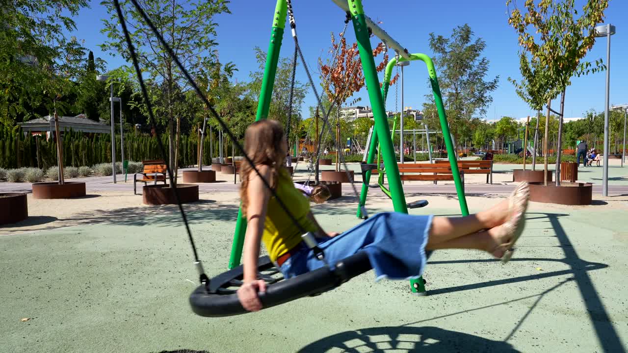 Mother and Daughter Playing on Swings in a Park