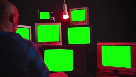 vintage tv's with chroma key screens in room with black wall