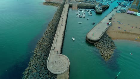 People-on-the-Pier-at-the-Bridport-Harbour-on-the-Dorset,-England-Coast---Aerial