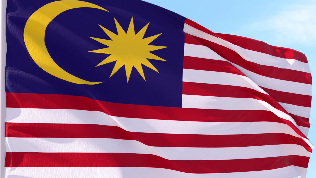 Bandiera della Malesia che sventola al vento contro il cielo blu