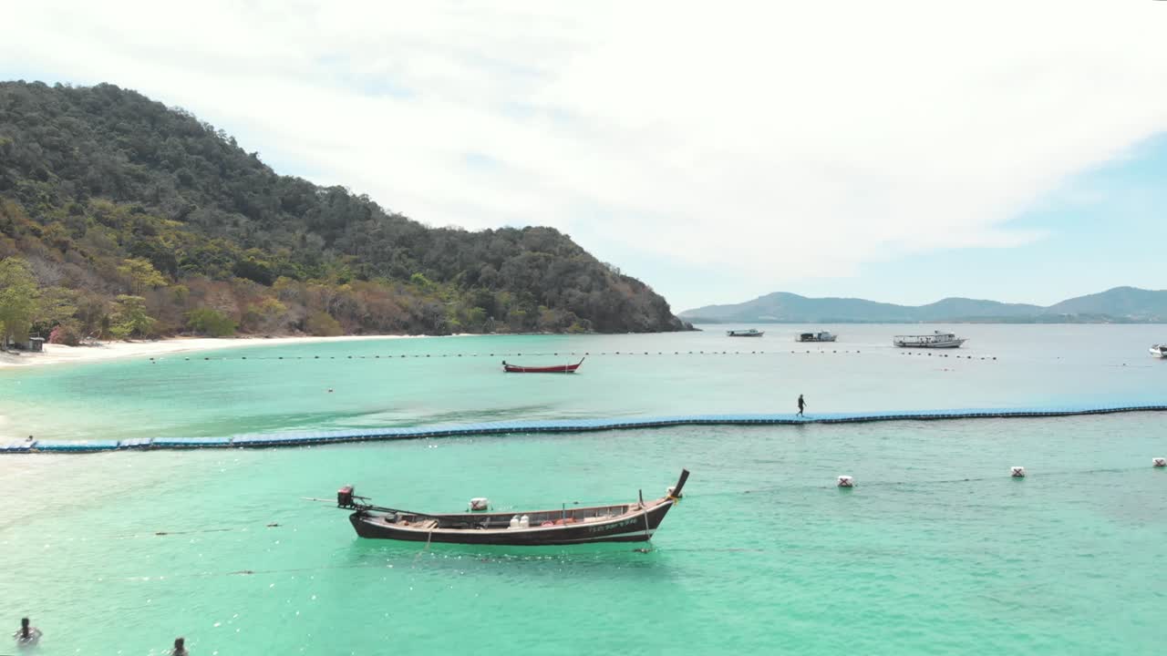 Molo turistico pedonale sopra acque smeraldo calme e poco profonde a Banana Beach, Koh Hey, Thailandia - Ripresa aerea in sorvolo.