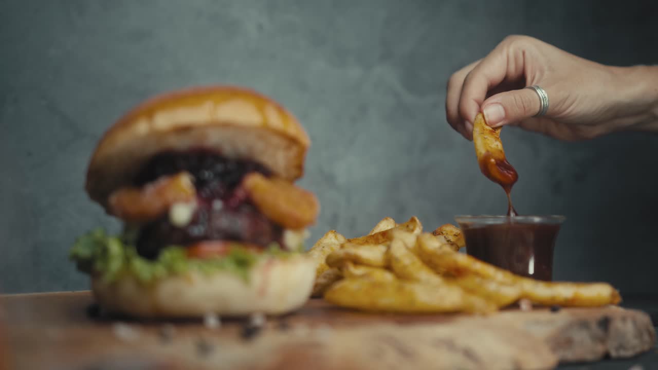 Hand picking a fry, Delicious burger and fries