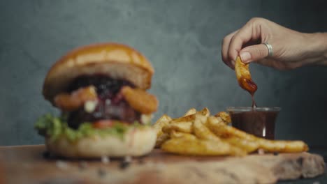 hand picking a fry, delicious burger and fries
