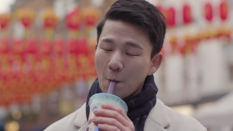 young asian couple on holiday drinking bubble tea in chinatown london uk 2