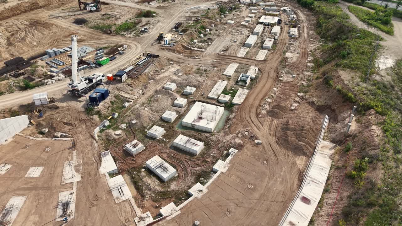 Drone-overflyvning af Vilnius’ nationale stadionbyggeplads med udgravningshul, fundamentblokke, kraner og jordarbejde, der viser det tidlige stadium af opbygningen af urban infrastruktur - 16. august 2025