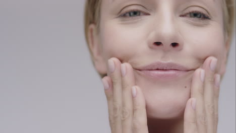 Beautiful-healthy-woman-touching-smooth-skin-on-face-in-slow-motion-for-beauty-skincare-concept-on-a-grey-background-Red-Epic-Dragon