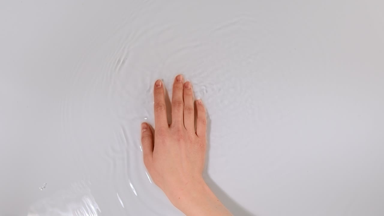 은 표면 물을 부드럽게 만지는 여성 손의 근접. 휴식과 친환경 환경.