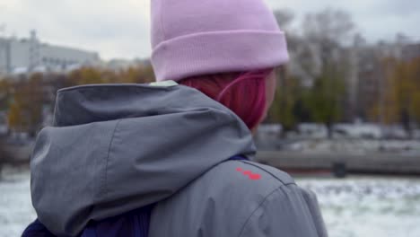 frau in rosa mütze und grauer jacke in einem park