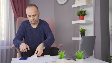 hombre preocupado debido a problemas financieros mirando facturas y deudas bancarias.