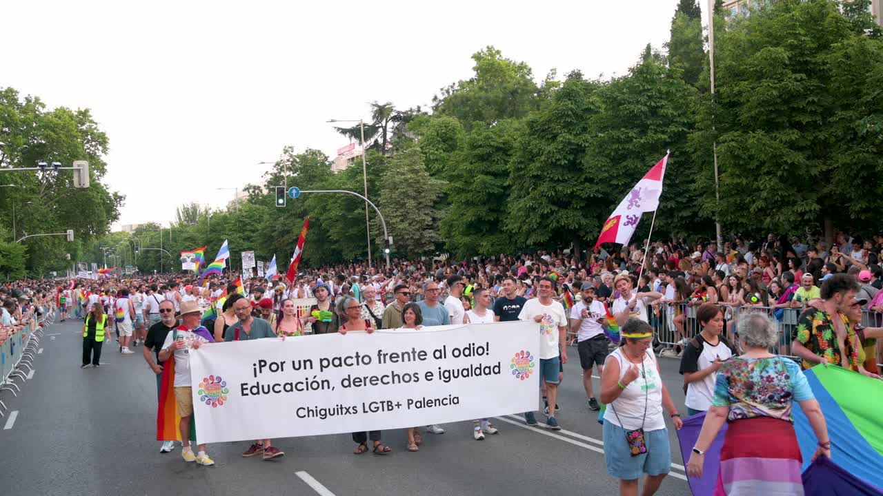 At the LGBTQIA Pride Month parade, thousands march through Madrid's streets, holding banners and waving rainbow flags to protest LGBTI discrimination and hate.