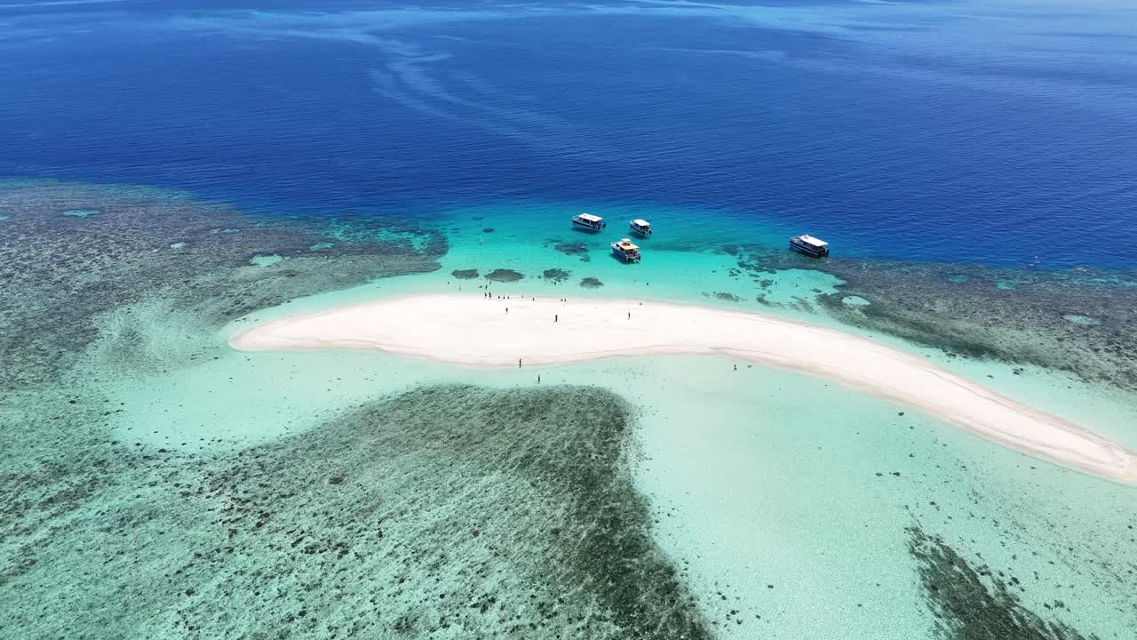aerial drone view of a pristine white sandbar in the Mamanuca Islands, Fiji. Crystal clear turquoise waters and vibrant coral reefs in a remote South Pacific paradise