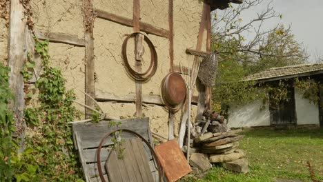 Alte-Landwirtschaftliche-Geräte-Hängen-Rustikale-Flechtwerk-Klecks-Fachwerk-Scheune,-Pan-Shot-Tag