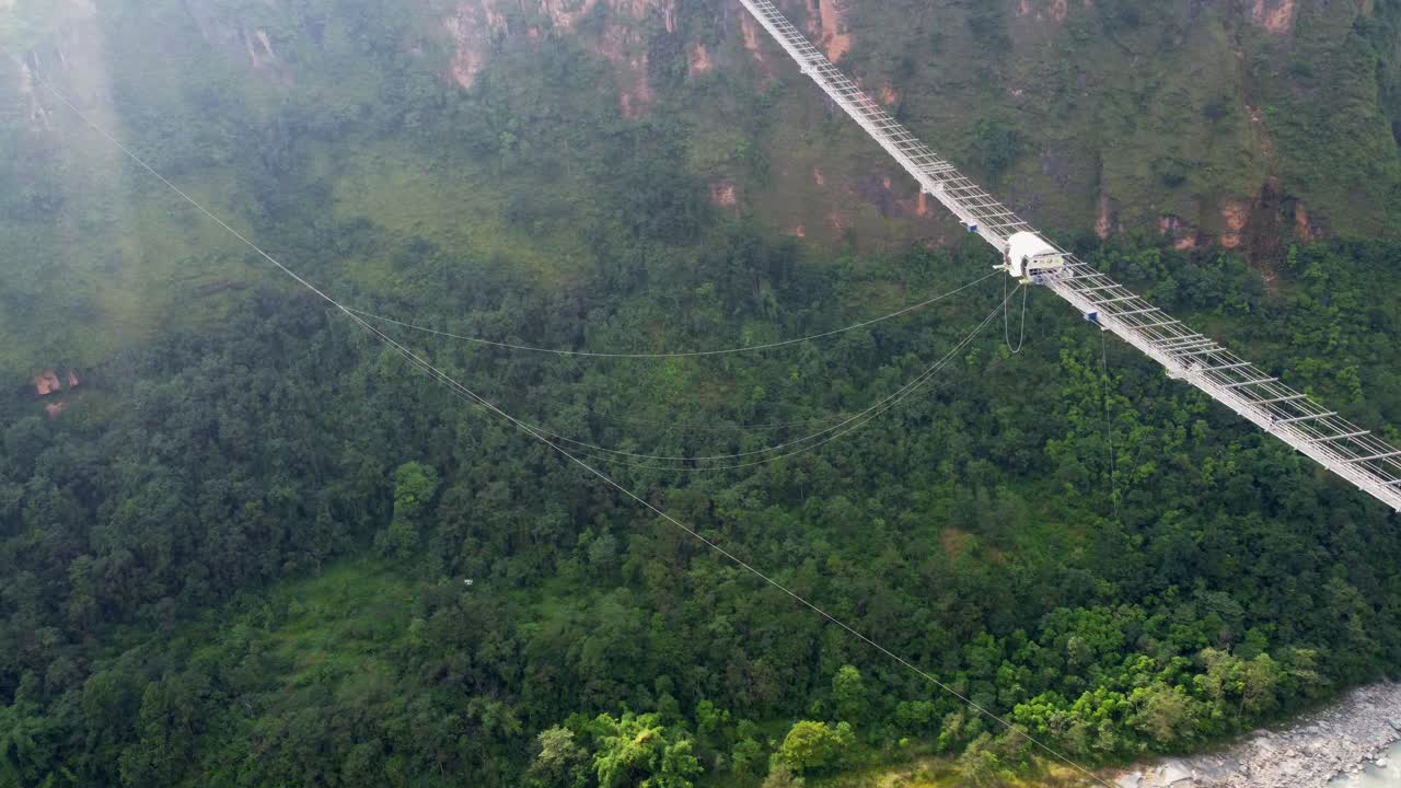 Aerial top down shot of bridge with bungee jumping in jungle of Nepal