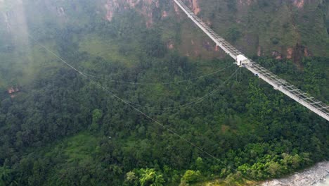 Toma-Aérea-De-Arriba-Hacia-Abajo-De-Un-Puente-Con-Puenting-En-La-Selva-De-Nepal