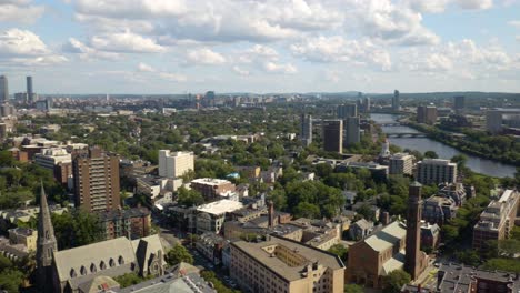 aerial pan left above cambridge, massachusetts with boston skyline in background on beautiful summer afternoon