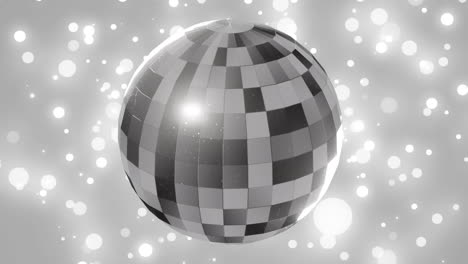 animation of mirror disco ball spinning over spots of lights on grey background