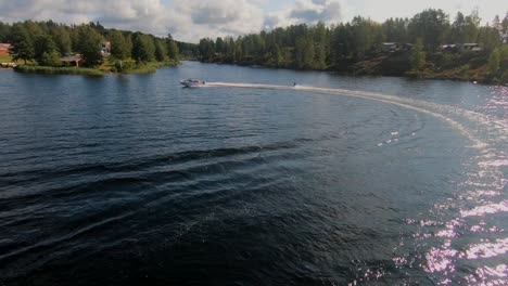 Drone-Volando-Sobre-Un-Joven-Montando-Un-Wakeboard-Después-De-Un-Bote-Deportivo-En-El-Archipiélago-Sueco-En-El-Verano