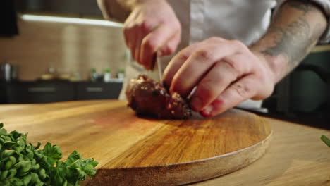 chef cutting meat on wooden board