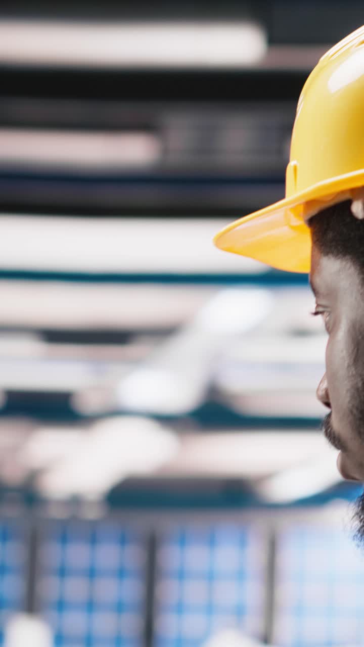 Vertical Video Black engineer in photovoltaics factory diagnoses malfunctioning systems