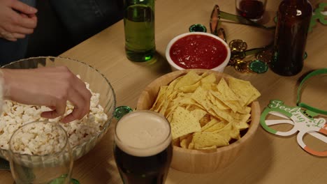 cerca de amigos en casa o en el bar celebrando en la fiesta del día de san patricio bebiendo alcohol con novedades y accesorios y bocadillos 2